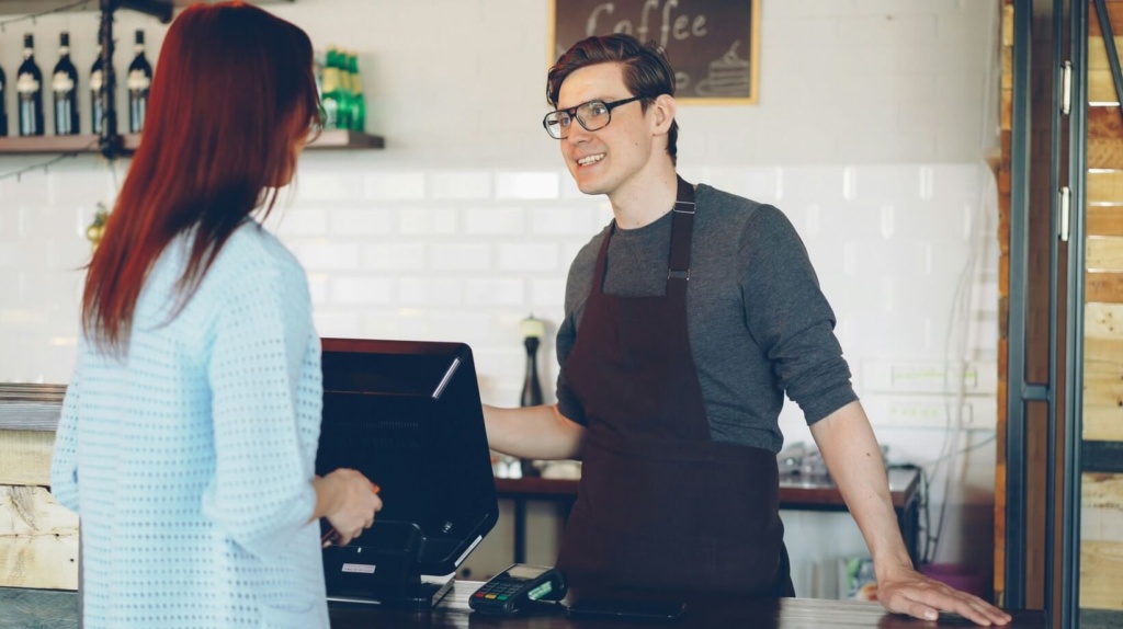 Barista Taking A Customer's Order At A Café Counter